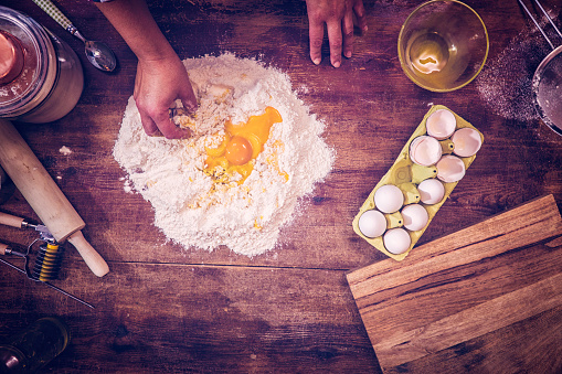Flour and eggs on the board ready to knead into homemade pasta dough